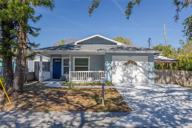 view of front of house with a porch, an attached garage, fence, concrete driveway, and stucco siding