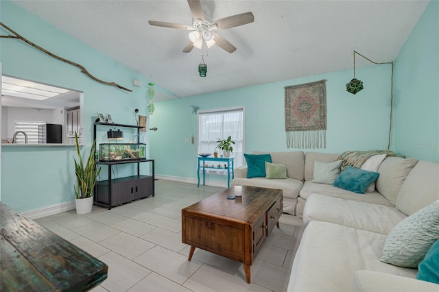 tiled living room with a textured ceiling, a ceiling fan, and a healthy amount of sunlight