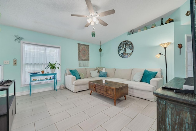 living area featuring vaulted ceiling, a textured ceiling, and ceiling fan