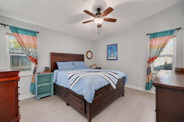 bedroom with vaulted ceiling, ceiling fan, and baseboards