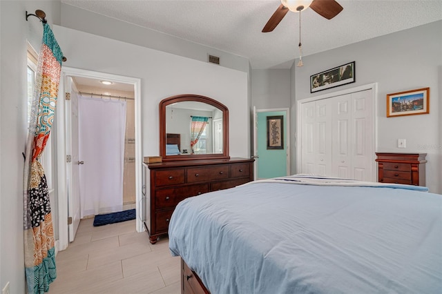 bedroom featuring a closet, visible vents, ceiling fan, and a textured ceiling