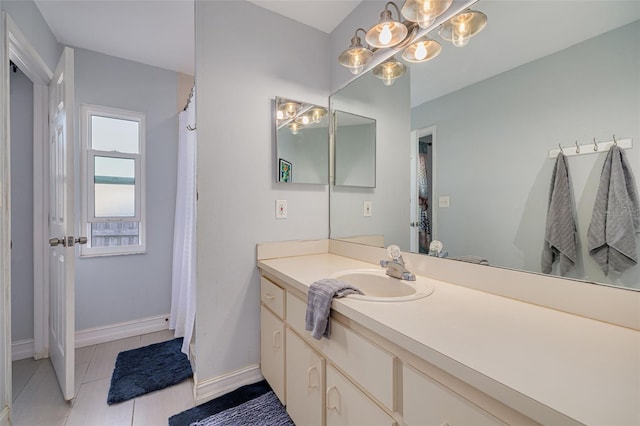 full bathroom with tile patterned flooring, baseboards, and vanity