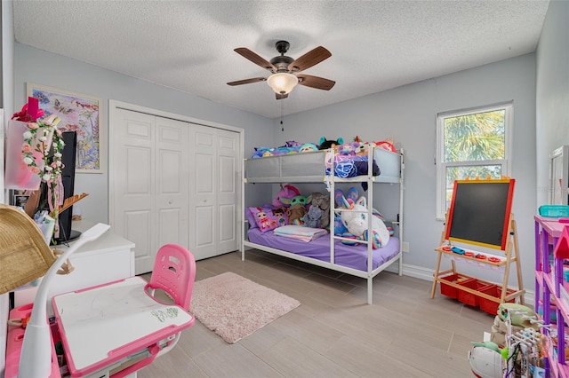 bedroom with ceiling fan, a closet, and a textured ceiling