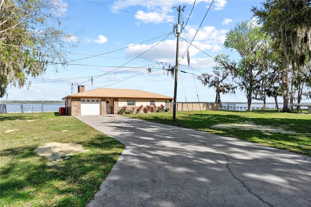 view of front of property featuring driveway, fence, and a front yard