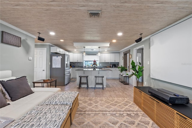 living room featuring ornamental molding, light wood-type flooring, visible vents, and recessed lighting