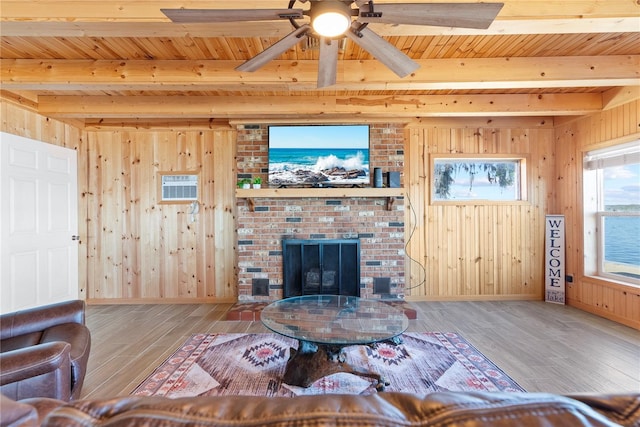 living area featuring beamed ceiling, wooden walls, and wood finished floors