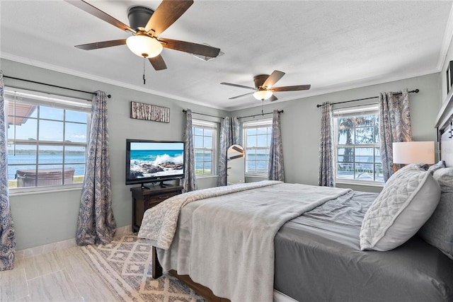 bedroom featuring a textured ceiling, baseboards, a ceiling fan, and crown molding