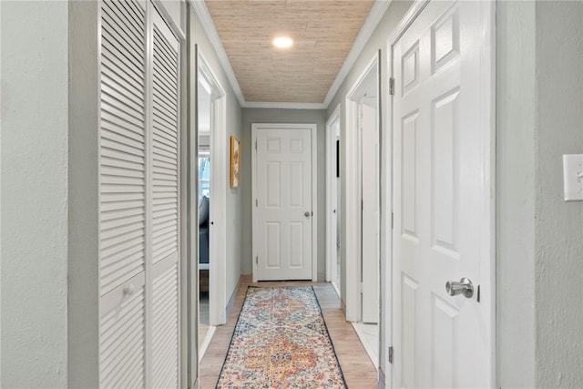 hall with ornamental molding and light wood finished floors