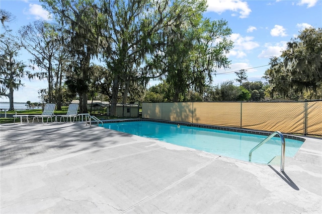 view of swimming pool featuring a patio, fence, and a fenced in pool