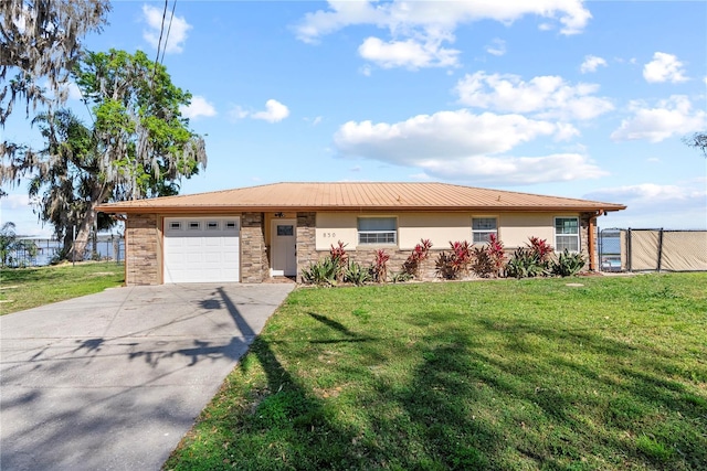 ranch-style house with stucco siding, concrete driveway, an attached garage, a front yard, and fence