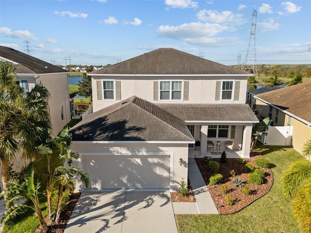 view of front of house featuring driveway, roof with shingles, fence, and stucco siding