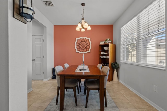 dining area featuring an inviting chandelier, light tile patterned flooring, visible vents, and baseboards