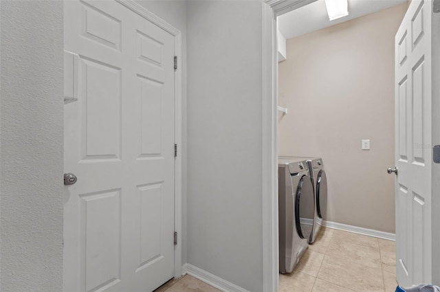 laundry room featuring laundry area, light tile patterned flooring, baseboards, and washing machine and clothes dryer