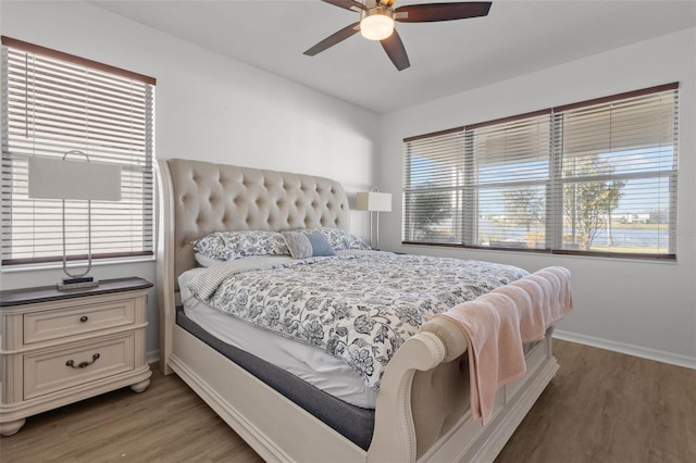 bedroom with baseboards, a ceiling fan, and light wood-style floors