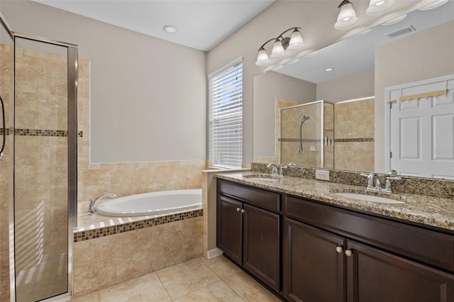 full bath featuring a bath, a stall shower, tile patterned flooring, and a sink