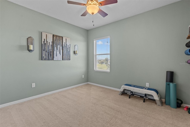 carpeted spare room featuring ceiling fan and baseboards