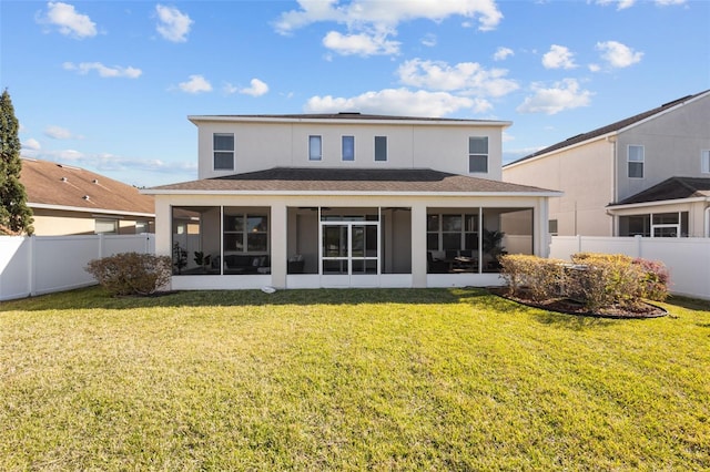 back of house featuring a sunroom, a fenced backyard, stucco siding, and a yard