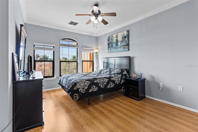 bedroom with wood finished floors, a ceiling fan, visible vents, baseboards, and ornamental molding