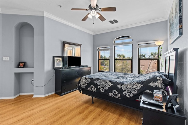 bedroom with baseboards, visible vents, a ceiling fan, wood finished floors, and crown molding