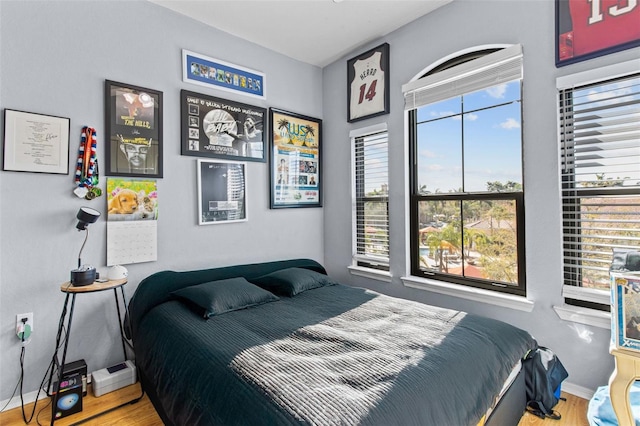 bedroom with baseboards and wood finished floors