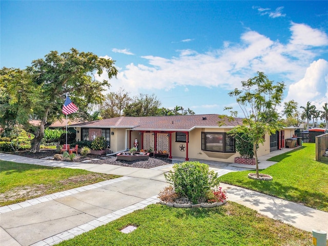 ranch-style house with driveway, a front yard, and stucco siding