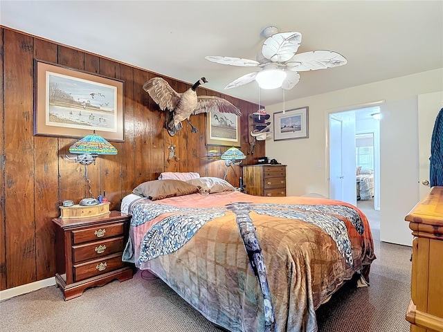 carpeted bedroom with wood walls and a ceiling fan