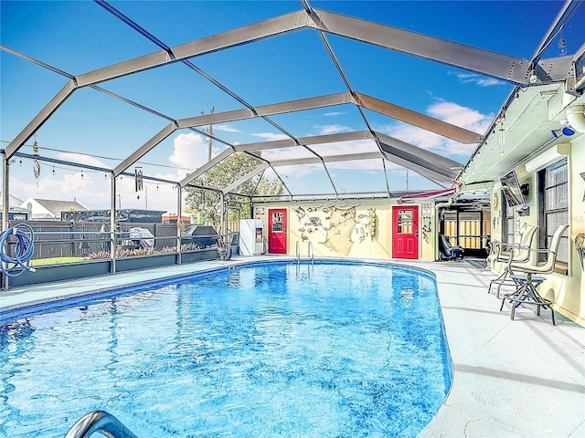 view of swimming pool with glass enclosure, a patio area, fence, and a fenced in pool