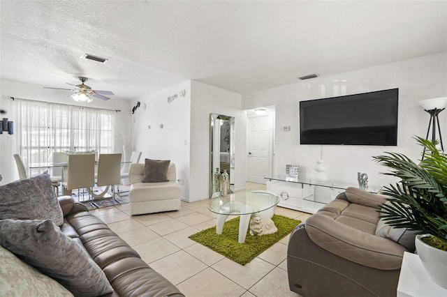 living room featuring light tile patterned floors, ceiling fan, a textured ceiling, and visible vents