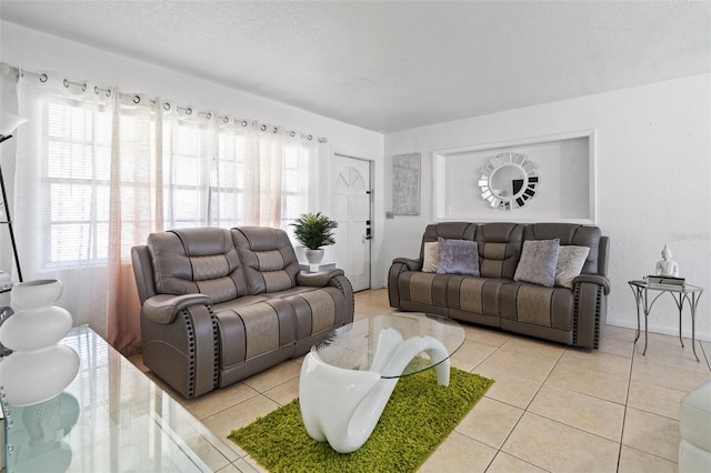 living area with light tile patterned floors, a textured ceiling, and a wealth of natural light