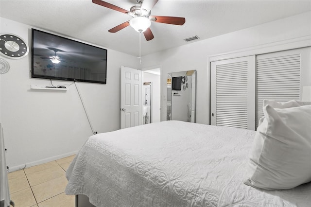 bedroom with light tile patterned floors, baseboards, visible vents, a ceiling fan, and a closet