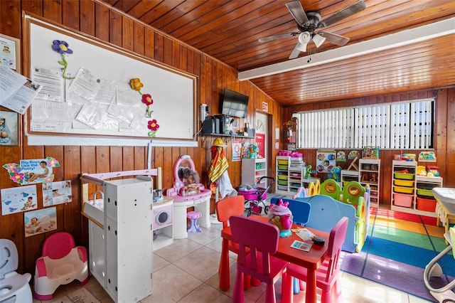 rec room with tile patterned flooring, wood ceiling, ceiling fan, and wooden walls