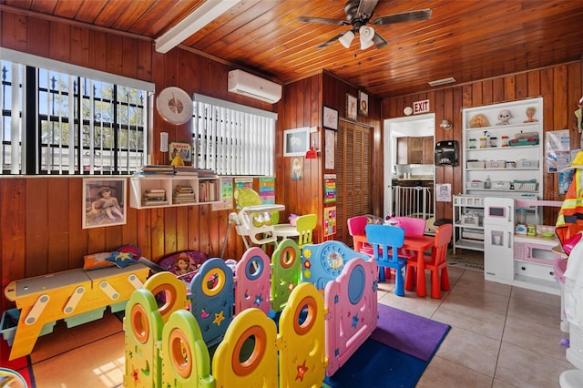 game room with a ceiling fan, wood ceiling, tile patterned flooring, wood walls, and a wall mounted AC