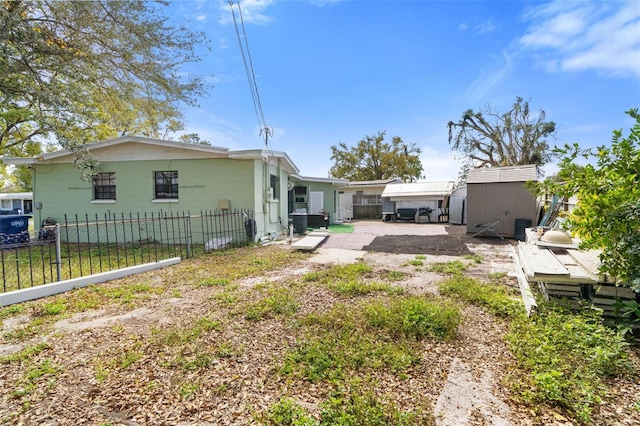 rear view of house featuring a patio, fence private yard, a storage unit, cooling unit, and an outdoor structure