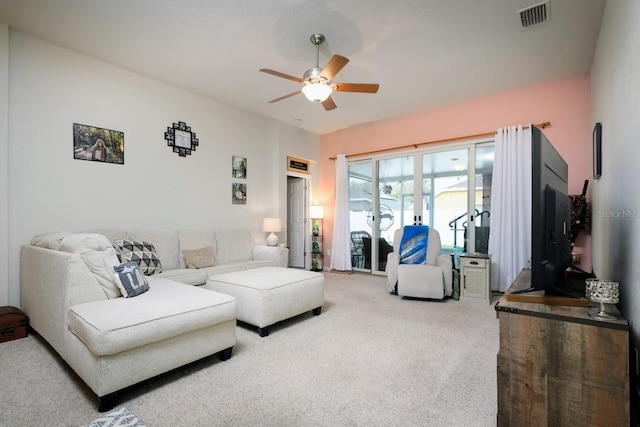 carpeted living room with ceiling fan and visible vents