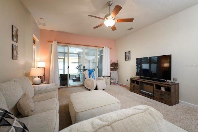 living area featuring a ceiling fan, light colored carpet, visible vents, and baseboards