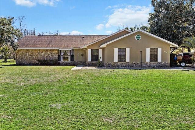 view of front facade featuring a front yard, stone siding, and stucco siding