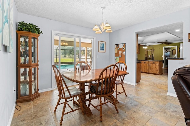 dining room featuring baseboards, a textured ceiling, and ceiling fan with notable chandelier