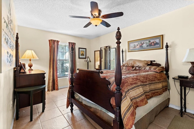 bedroom featuring light tile patterned floors, baseboards, a ceiling fan, and a textured ceiling