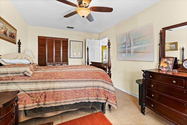 bedroom with baseboards, visible vents, a ceiling fan, tile patterned floors, and a textured ceiling