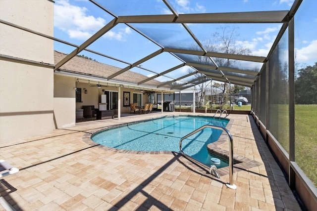 outdoor pool with a lanai, a patio area, and ceiling fan