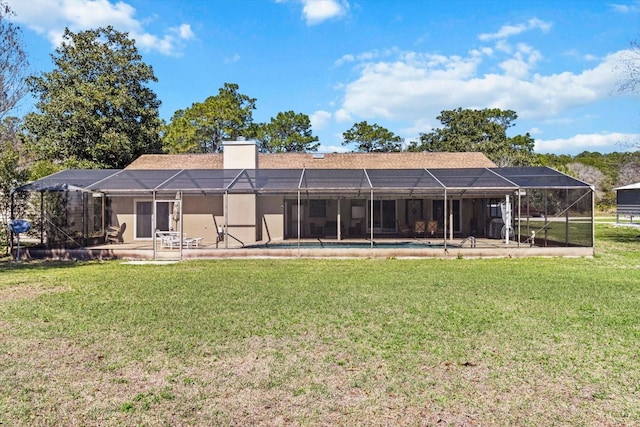 back of property with glass enclosure, an outdoor pool, a chimney, and a lawn