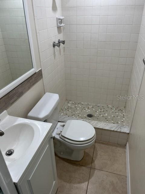 full bath with tile patterned flooring, a shower stall, toilet, and vanity