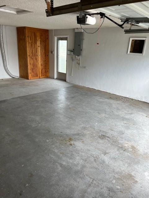 garage featuring electric panel and a garage door opener