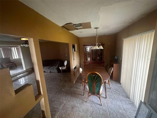 dining area with vaulted ceiling, a textured ceiling, and light tile patterned floors