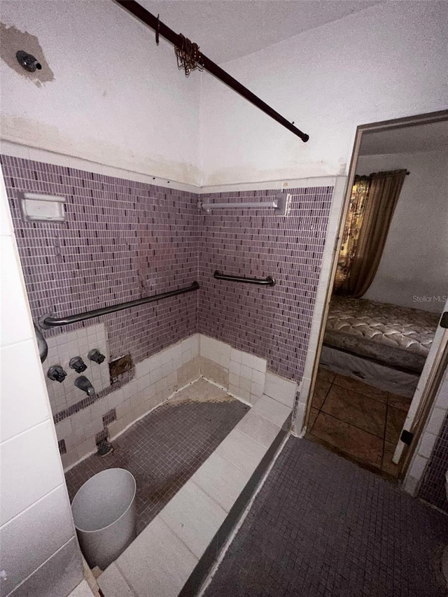 bathroom with tile patterned flooring, a textured ceiling, and tiled shower