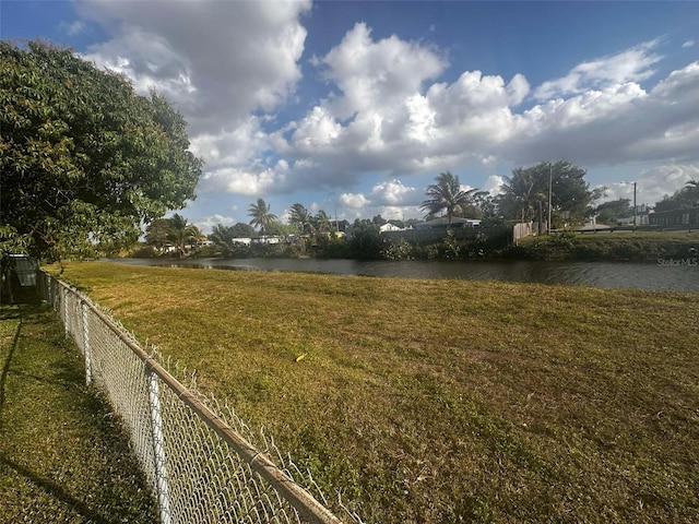 view of yard featuring a water view and fence