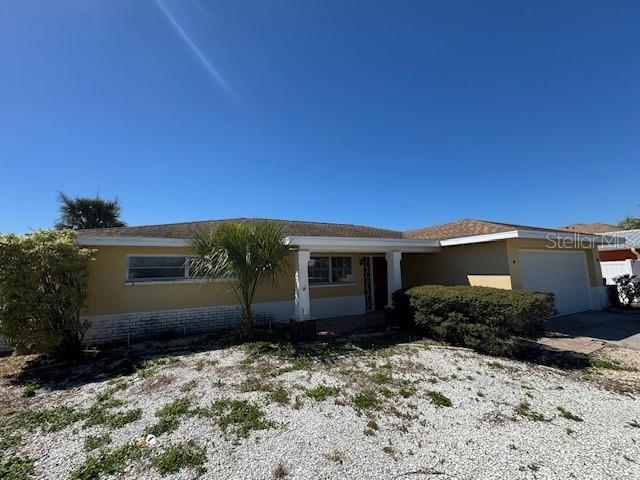 ranch-style home with a garage, driveway, and stucco siding