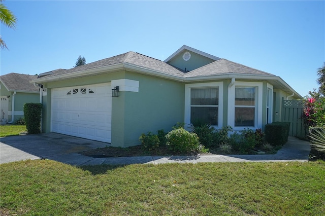 view of front of home with an attached garage, a shingled roof, driveway, stucco siding, and a front yard