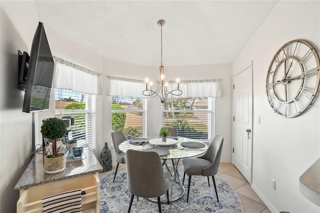 dining room with light tile patterned floors, baseboards, and a notable chandelier