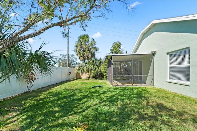 view of yard featuring a sunroom and a fenced backyard